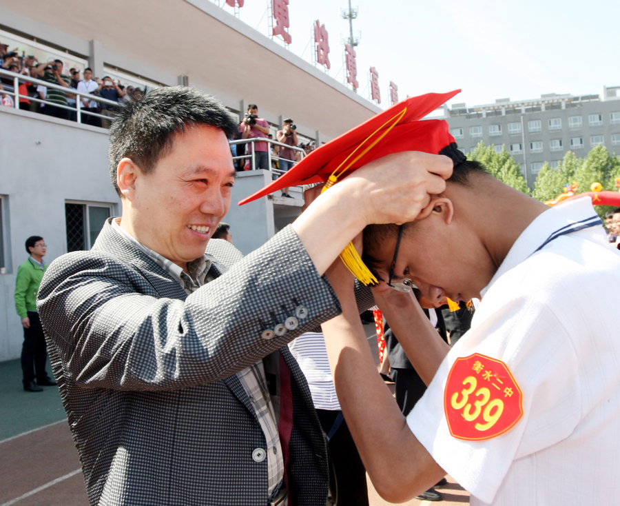校党委书记、校长秦海地为学生戴成人帽