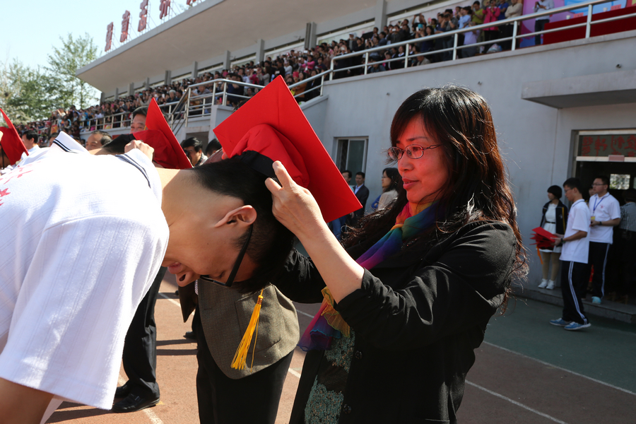 校党委书记、校长秦海地为学生戴成人帽